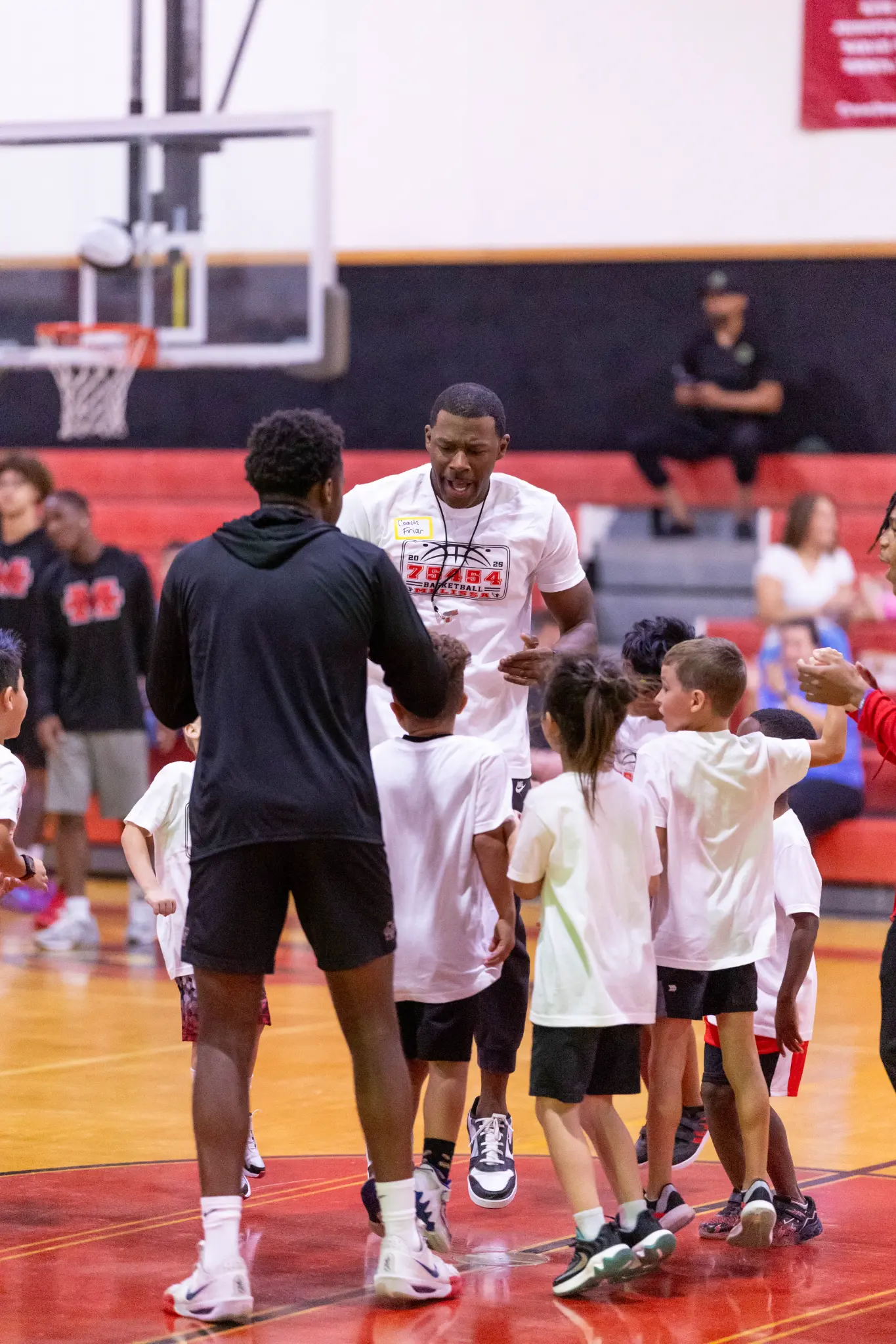 Founder coaching children on a basketball court