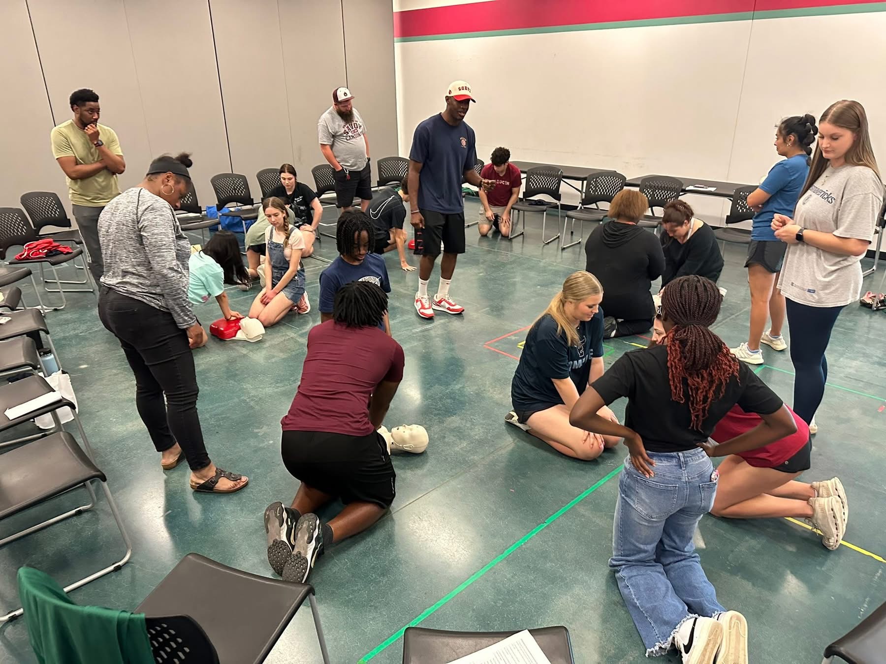 Real CPR training class with students practicing hands-on compressions